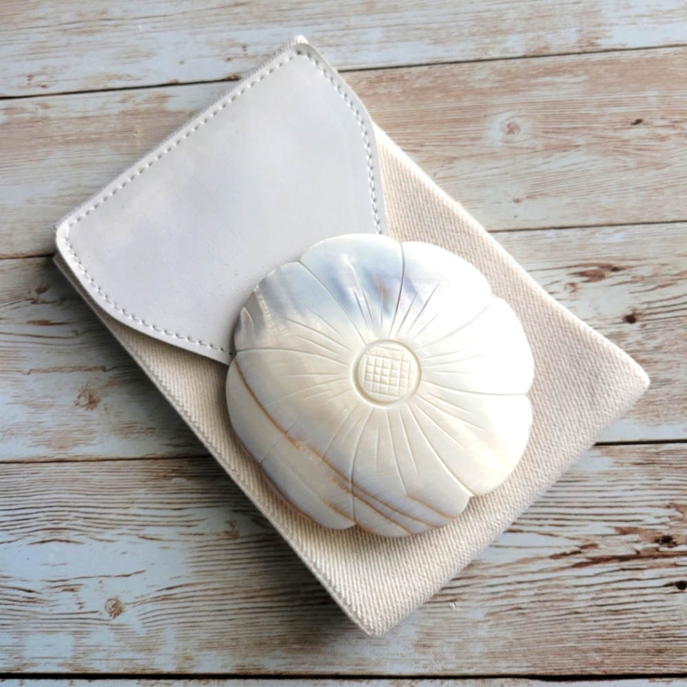 White elastic cinch belt with shell carved into a flower